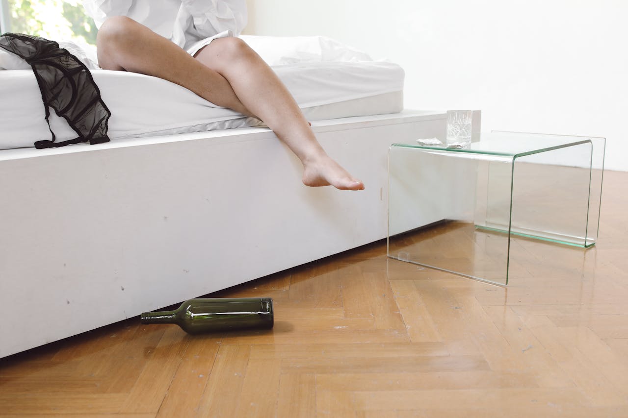 Relaxed morning after a party with wine bottle on wooden floor.